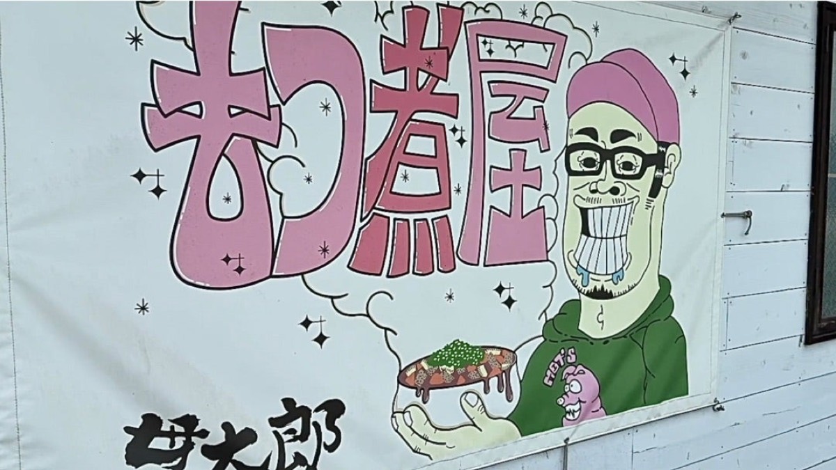 白い幕に描かれた「もつ煮屋」の文字と、湯気の立つ器を手にした店主のイラスト。左下に筆文字で「貫太郎」