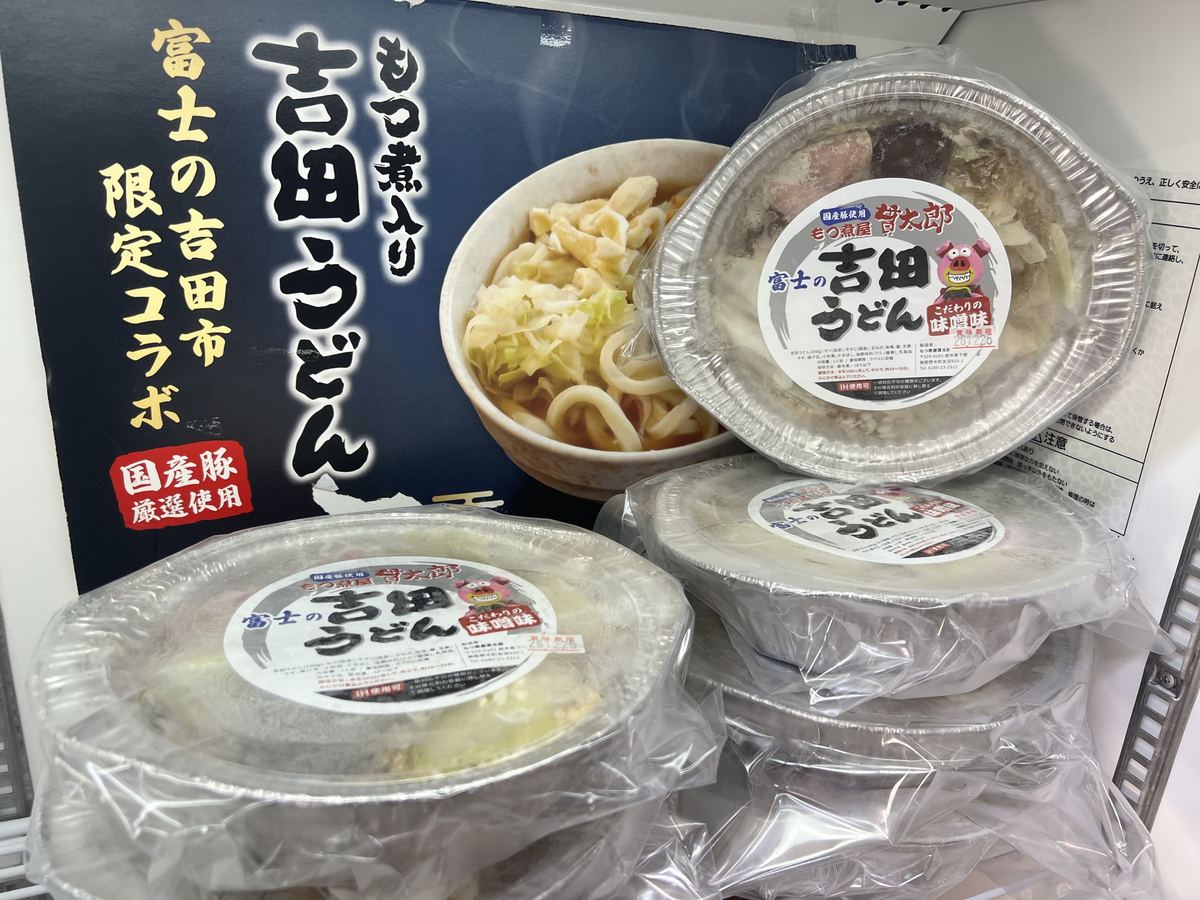 冷凍の吉田もつうどんのパックと「富士の吉田市 限定コラボ」の掲示